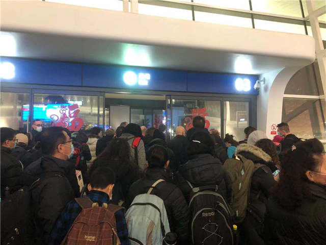 搭上首班撤侨班机的旅客，在天河机场排队等候。